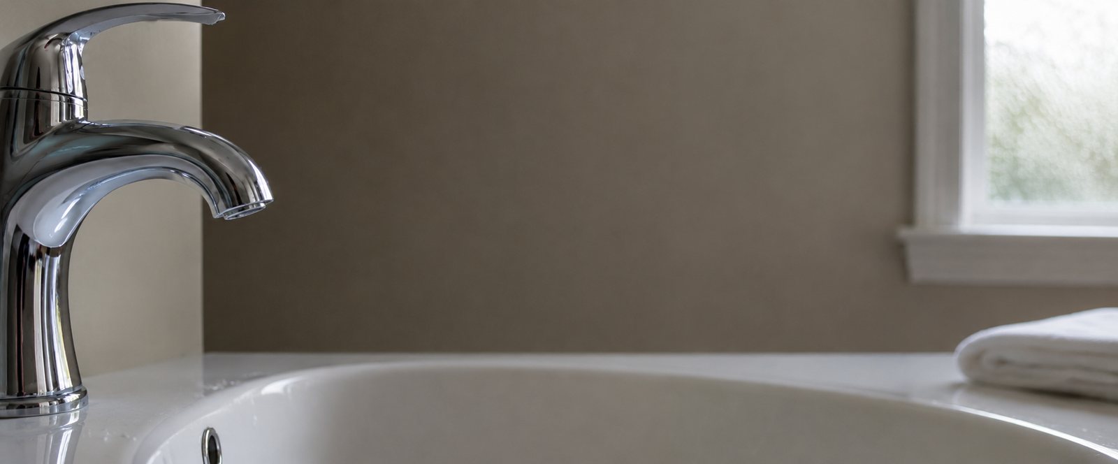 Close-up of a chrome faucet and a clean white sink