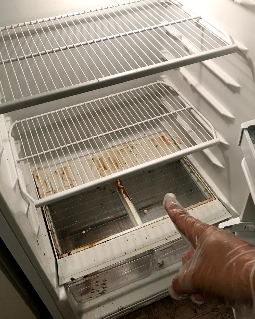 A fridge before a Vitrine Home Service clean: stained shelves and drawers